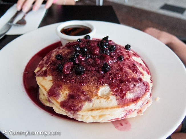 Pancake stack with berries and maple syrup